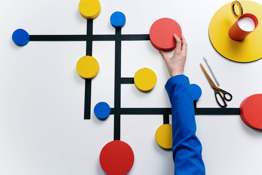 Abstract artwork featuring vibrant geometric shapes and human hand interaction on a white background.