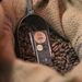 Chocolate bar in scoop on cocoa beans in burlap sack, showcasing premium chocolate production.