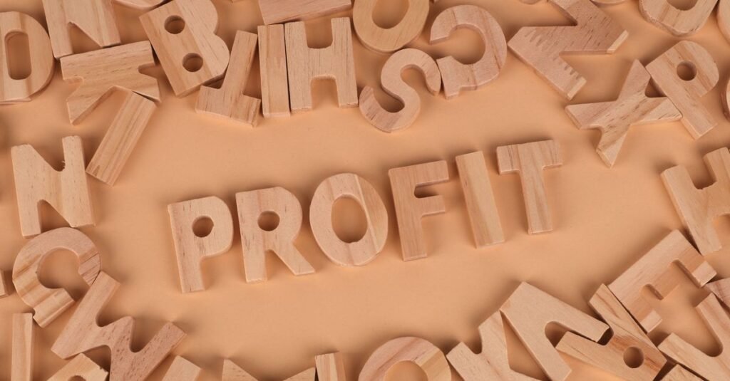Wooden letters scattered on a table with 'PROFIT' prominently displayed.