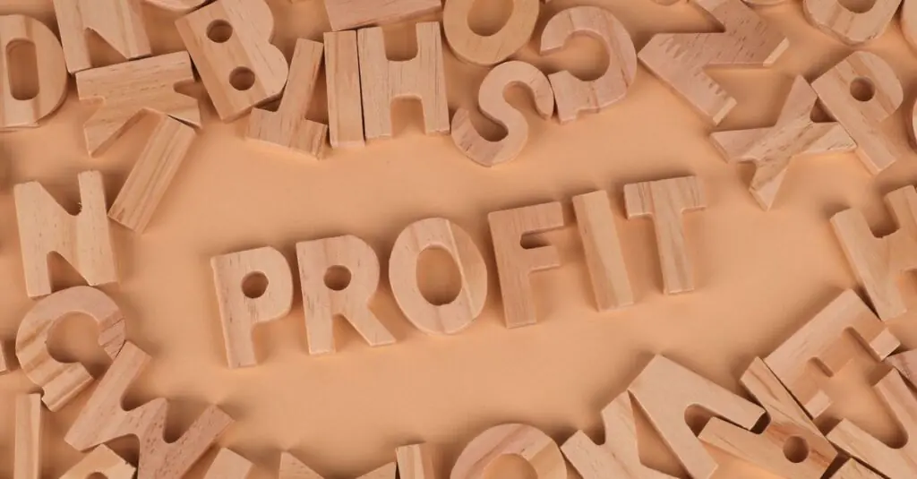 Wooden letters scattered on a table with 'PROFIT' prominently displayed.