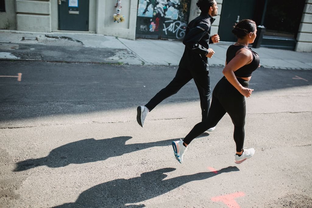 A man and woman jogging on a city street, capturing vitality and motion.