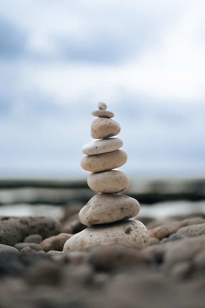 A close-up of smooth, stacked stones on a pebbly beach, offering a serene and balanced aesthetic.