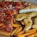 A close-up shot of pizza, Spanish omelette, sweet potato fries, and nuggets on a wooden table.
