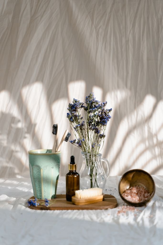 A serene arrangement of spa essentials including a bottle, flowers, and salt for a relaxing atmosphere.