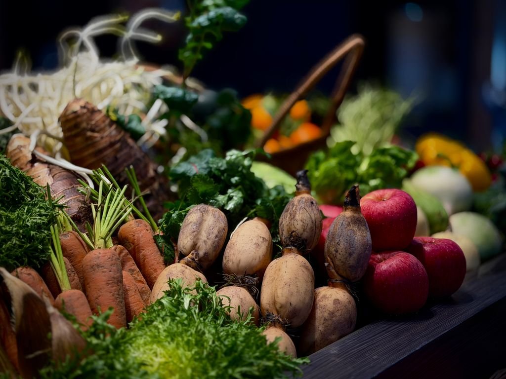 A vibrant display of fresh vegetables and fruits including carrots, apples, and greens. food