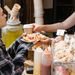 A young woman receives a delicious waffle and coffee at a street food stall.