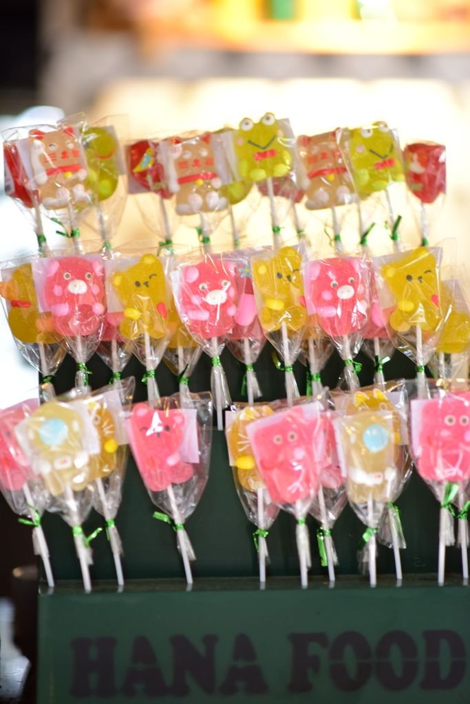 Brightly colored animal-shaped lollipops on display at a food stall.