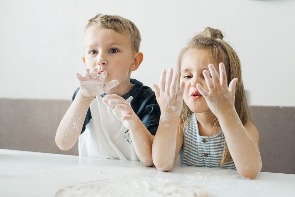 Children playing with flour at home, showcasing fun and creativity in the kitchen.
