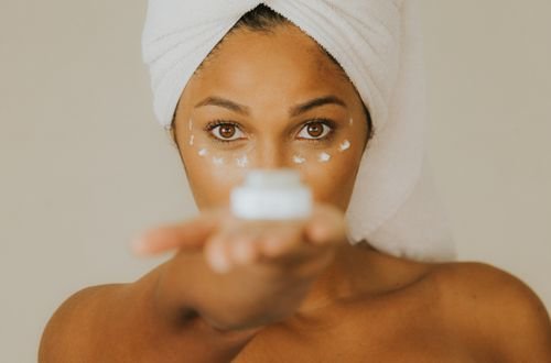 Close-up of a woman holding a facial cream jar focusing on skincare practice.