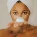 Close-up of a woman holding a facial cream jar focusing on skincare practice.