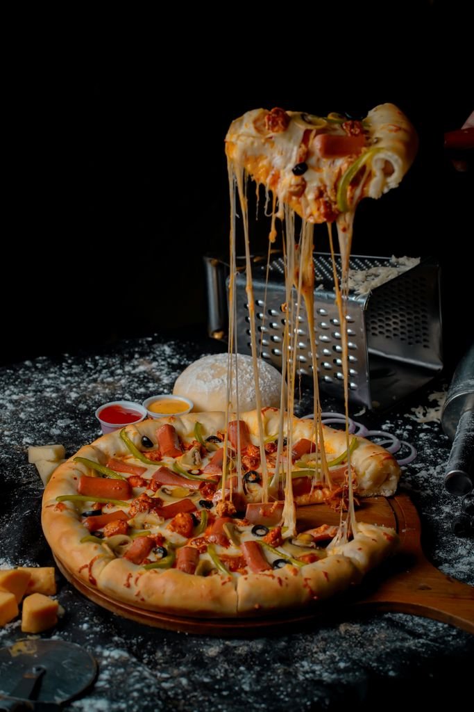 Delicious cheese burst pizza topped with vegetables and herbs, oozing with melted cheese. food
