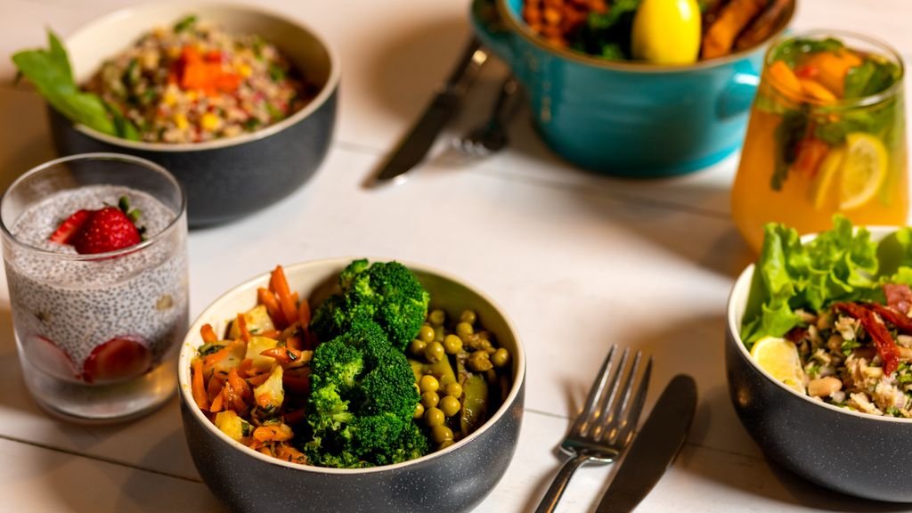 Delicious colorful bowls of salad and fresh beverages on a white table, perfect for healthy dining. food