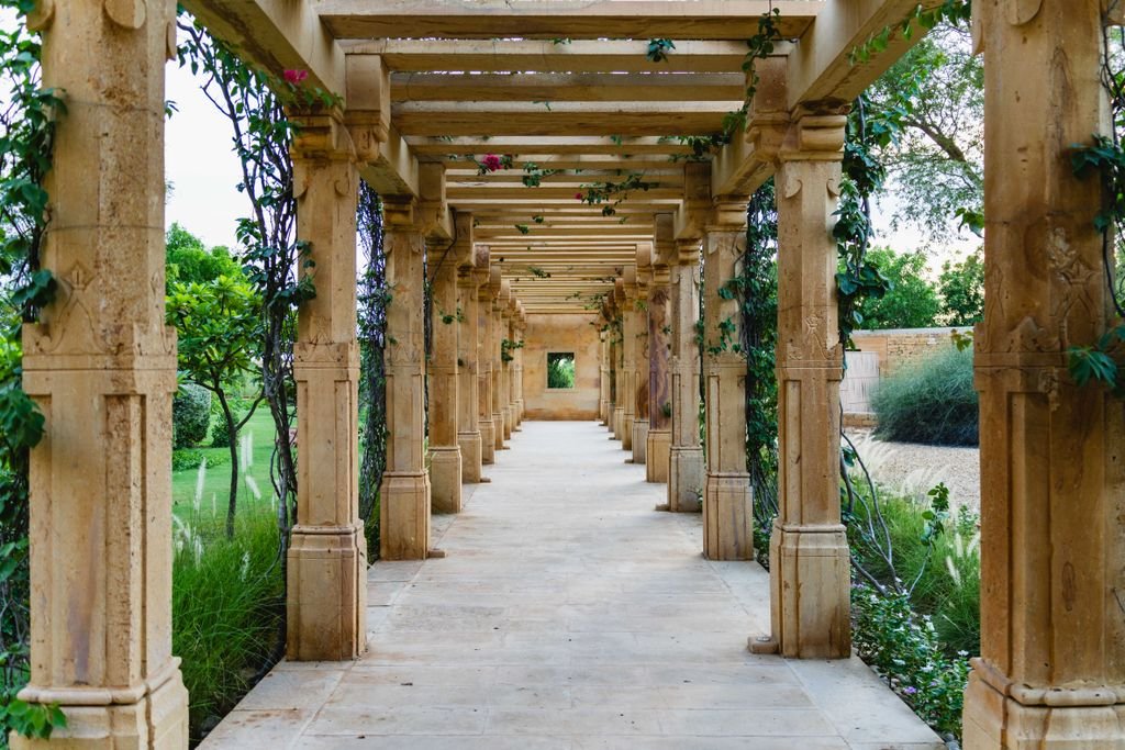 Explore a tranquil garden walkway with stone pillars, located in Jaisalmer, Rajasthan, India.