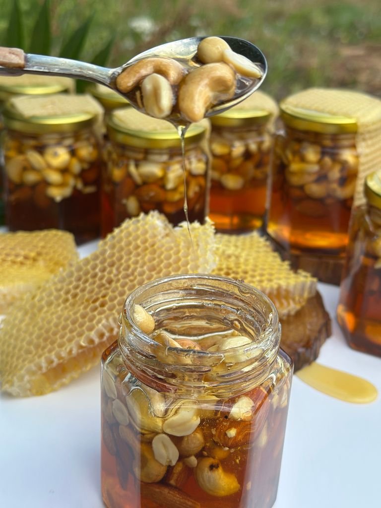 Jars of honey and nuts with honeycomb, showcasing rich textures and natural sweetness.
