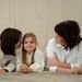 Three generations of women smiling together, symbolizing familial love and connection.