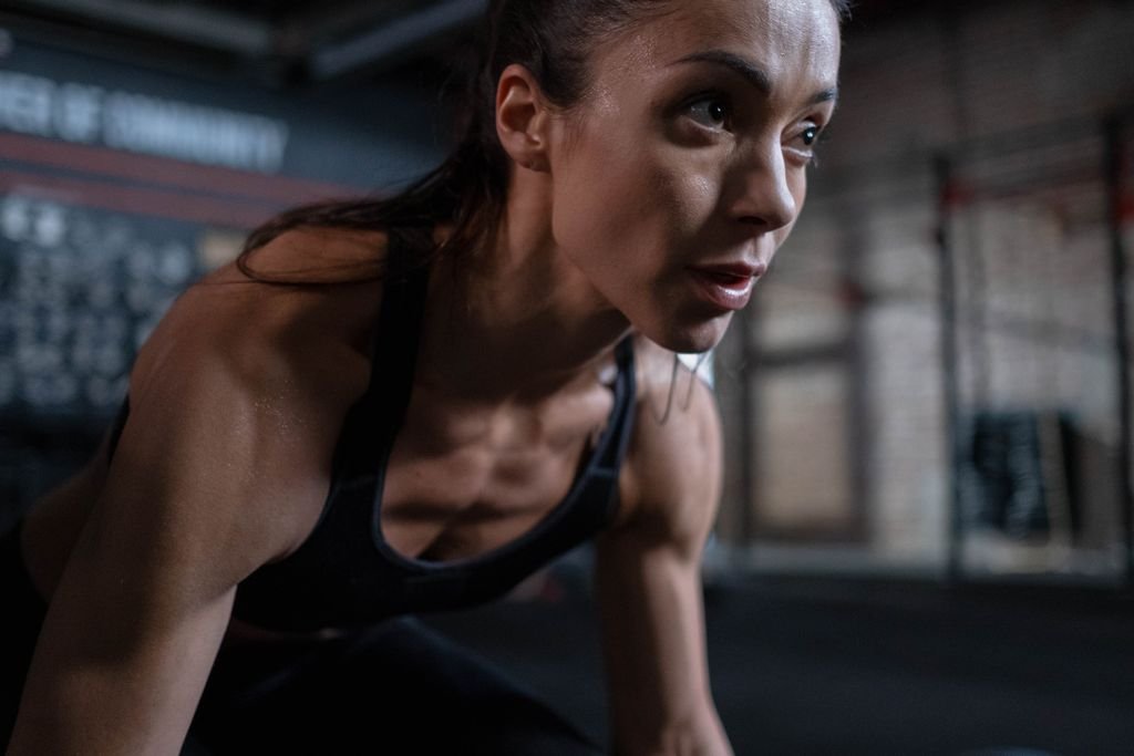 Close-up of a determined female athlete sweating during a workout session indoors. nylon