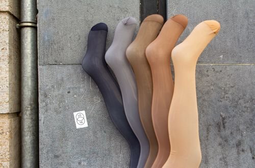 Five colored stockings on a concrete backdrop showcasing diversity in fashion.