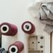 Flat lay of sewing materials including spools of thread and fabric on a workbench, ideal for crafting and textile themes.
