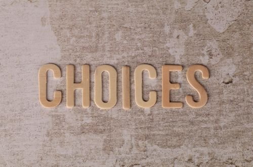 Wooden letters spelling 'choices' on a textured surface, symbolizing decision-making.