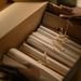 Hands organizing files in a box, symbolizing investigation and research.