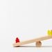 Wooden seesaw toy with colorful figures illustrating balance and play in a minimalist style.